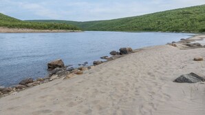 A riverbank with a sandy shore and rocks. - Nilla 3 by Interhome (Utsjoki)