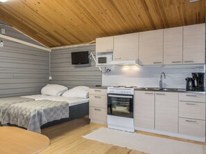 A compact kitchen with a microwave, oven, and sink.