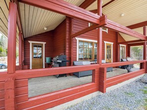 A wooden cabin with a porch, a grill, and a seating area. - Kaskenhovi by Interhome (Parkano)