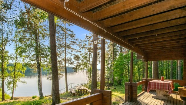 A wooden deck with a view of a lake and trees. - Vacation home Utras by Interhome (Savonlinna)