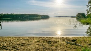 A calm lake with a clear sky and sunlight reflecting on the water. - Vacation home Utras by Interhome (Savonlinna)