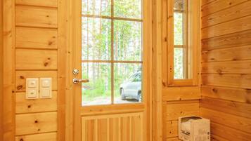 Eine Holztür mit Fenster, ein geparktes Auto davor und eine Kiste auf einem Regal.