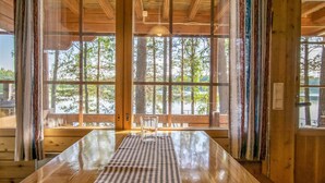A wooden interior with large windows, a checkered table, and a bench. - Vacation home Utras by Interhome (Savonlinna)
