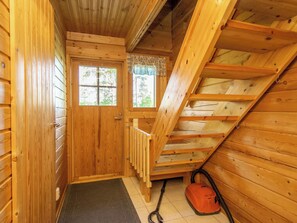 A wooden interior with a staircase, a door, and a window.