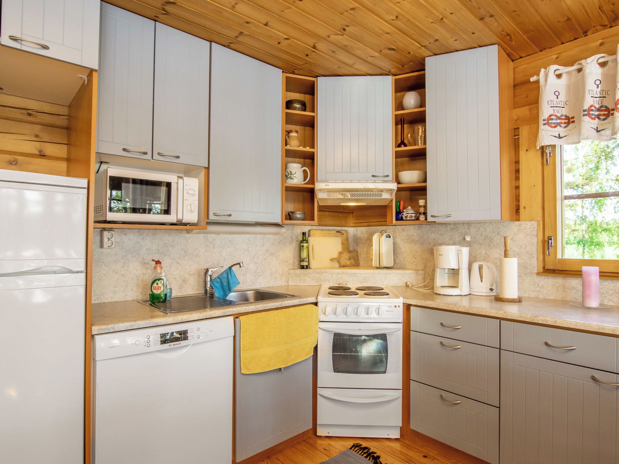 A compact kitchen with white cabinets, a microwave, a stove, and a dishwasher.