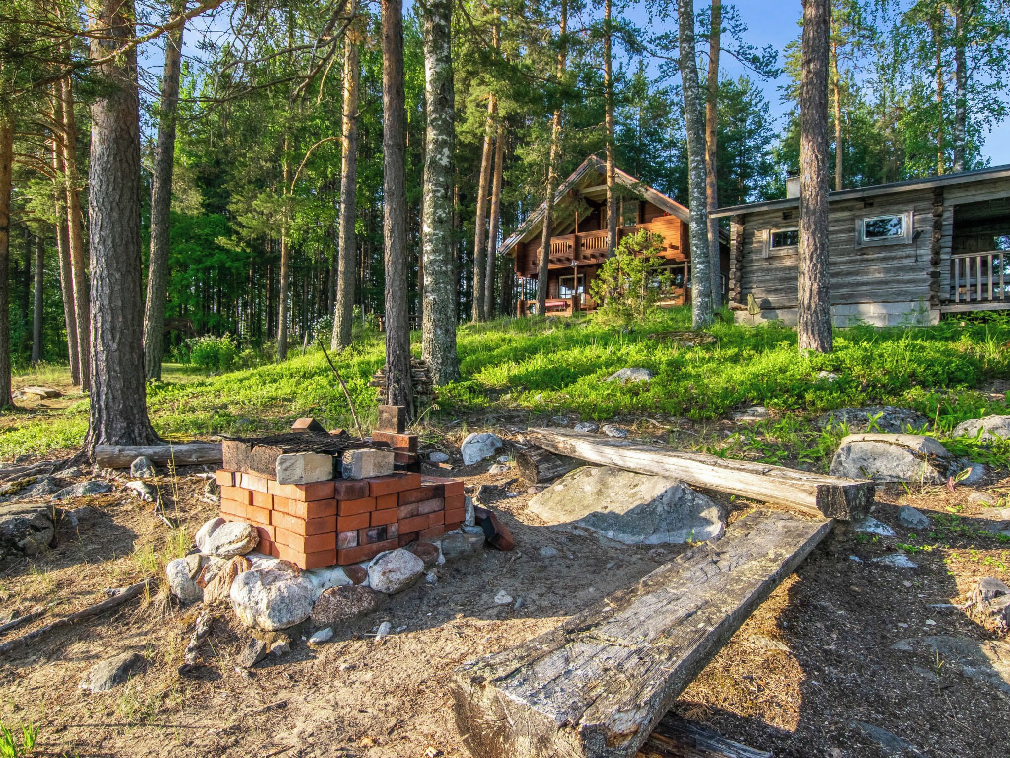 Eine Hütte, umgeben von Wald, mit einem Stapel Ziegelsteinen und Baumaterialien.