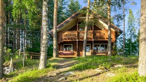 A cabin with a wooden exterior, multiple balconies, and a porch area. - Vacation home Utras by Interhome (Savonlinna)