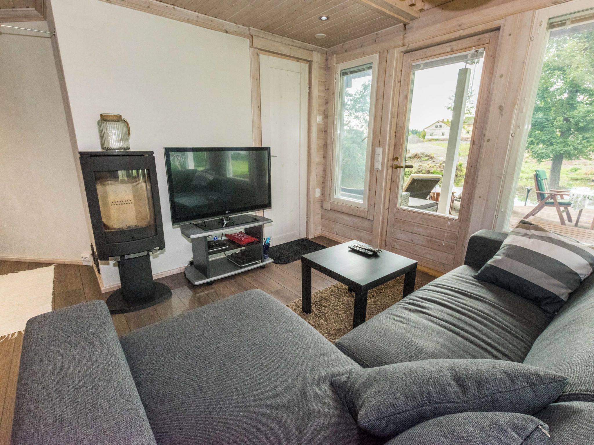 Een woonkamer met een bank, een televisie en een bijzettafeltje.