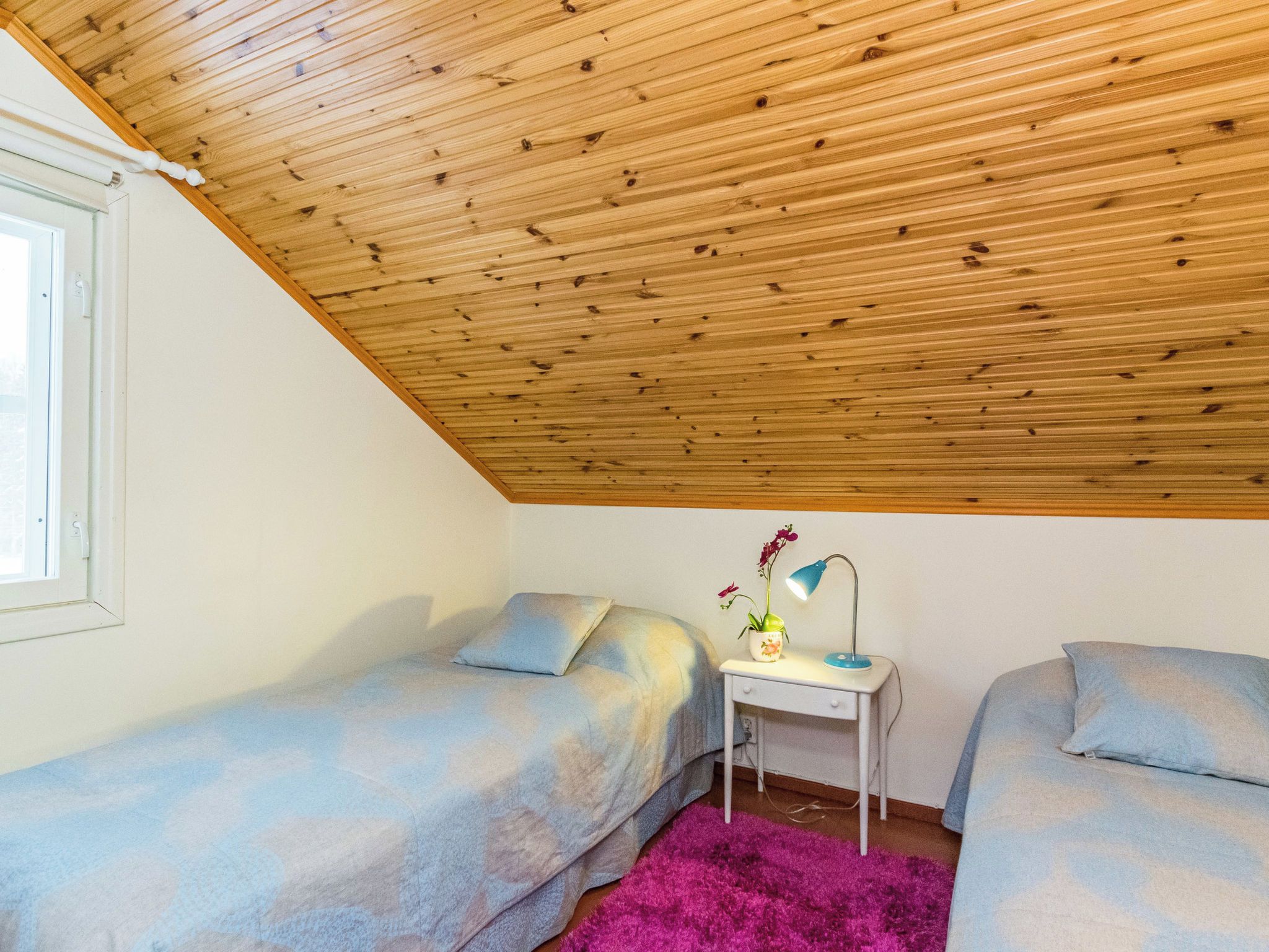 Una camera da letto con due letti singoli, una scrivania con una lampada e una finestra.