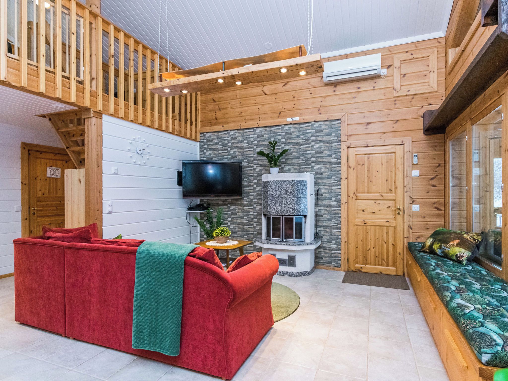 Ein modernes Interieur mit einem roten Sofa, einem Kamin und einem Fernseher.