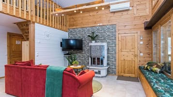 Ein modernes Interieur mit einem roten Sofa, einem Kamin und einem Fernseher.