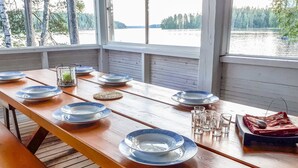Ein Holztisch ist für ein Essen gedeckt, mit Tellern, Gläsern und einem kleinen dekorativen Gegenstand.