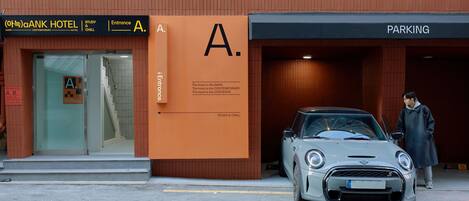 A building with a sign reading "ANK HOTEL" and "PARKING" on the right.