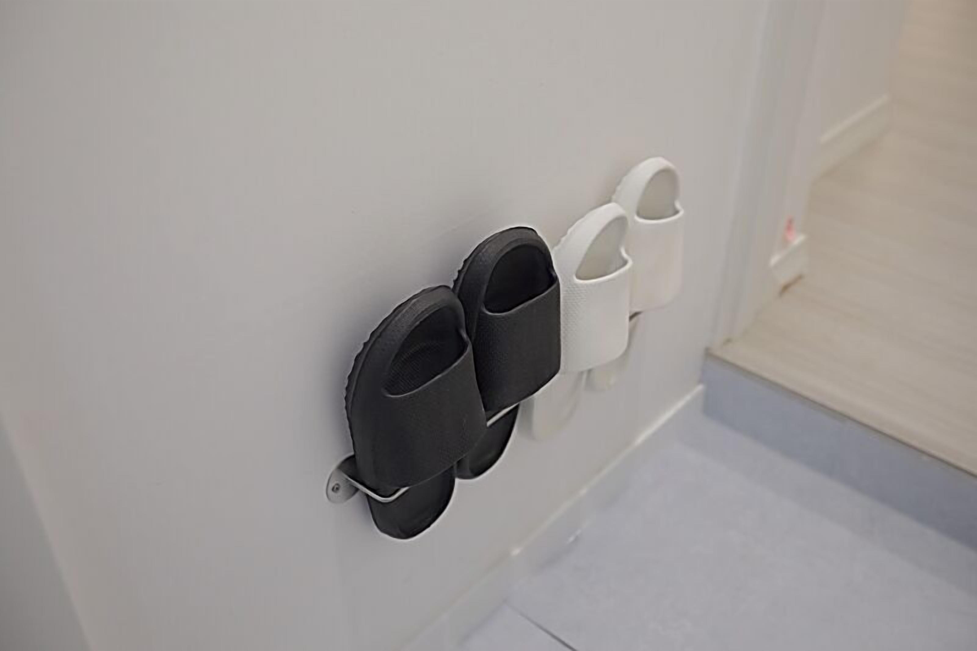 A wall-mounted shoe rack with black and white shoes.