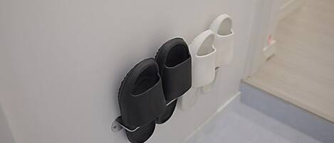 A wall-mounted shoe rack with black and white shoes.