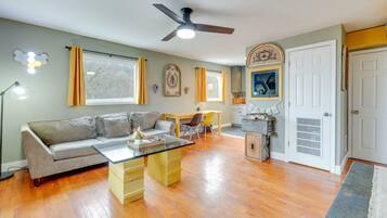 Relax in this open-plan living space featuring a sofa set, dining area, and kitchen.