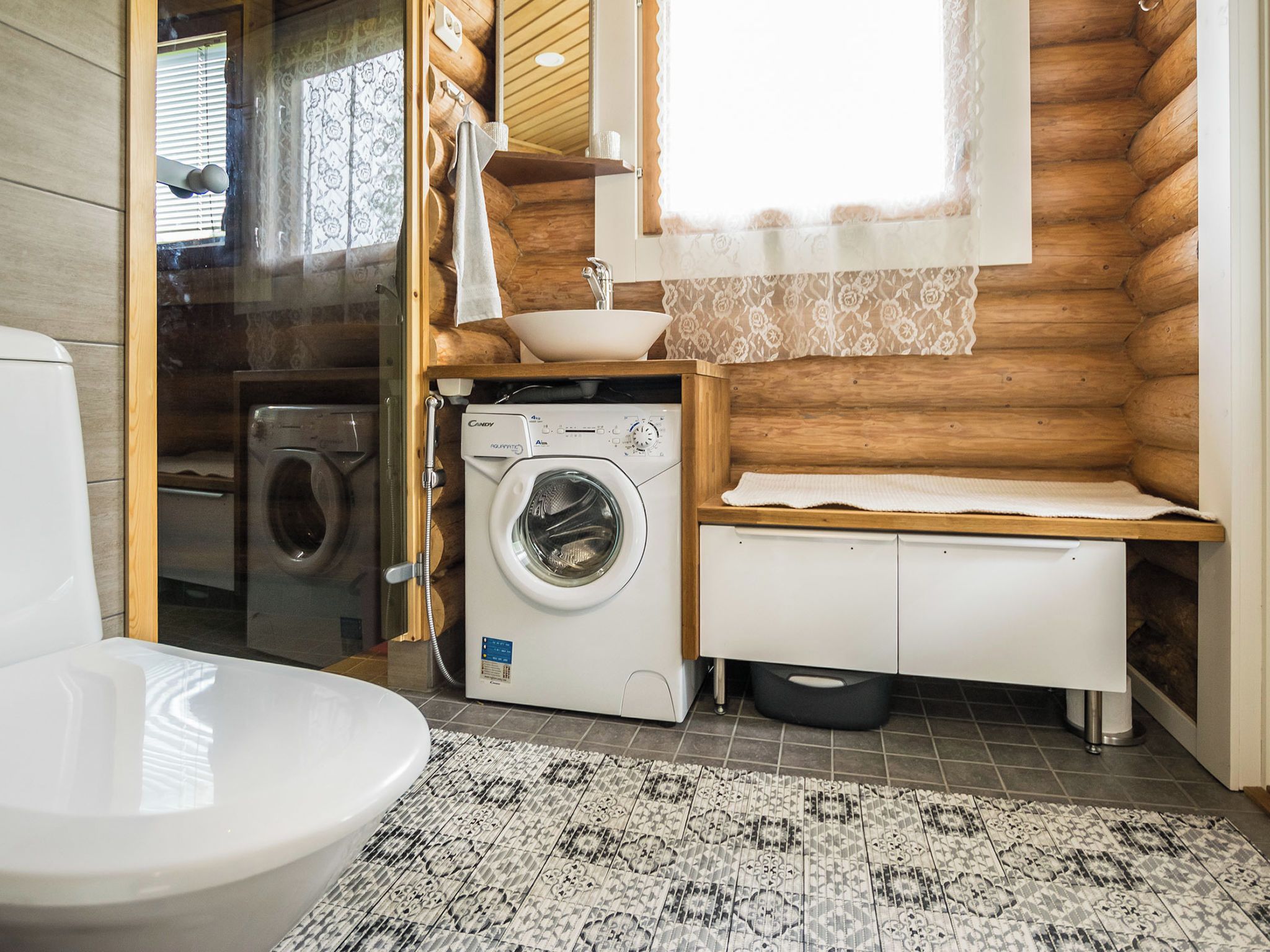 Ein kleines Badezimmer mit Waschmaschine, Toilette und Waschbecken.