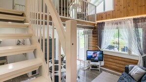 A multi-level wooden interior with a staircase, a television, and a seating area. - Kaislaranta by Interhome (Suonenjoki)