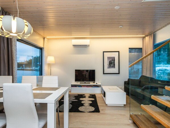 A modern living room with a dining area, a TV, and a staircase. - Villa joutseno by Interhome (Imatra)