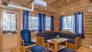 L'intérieur d'une cabane en rondins, avec un banc en bois, une chaise et une table.