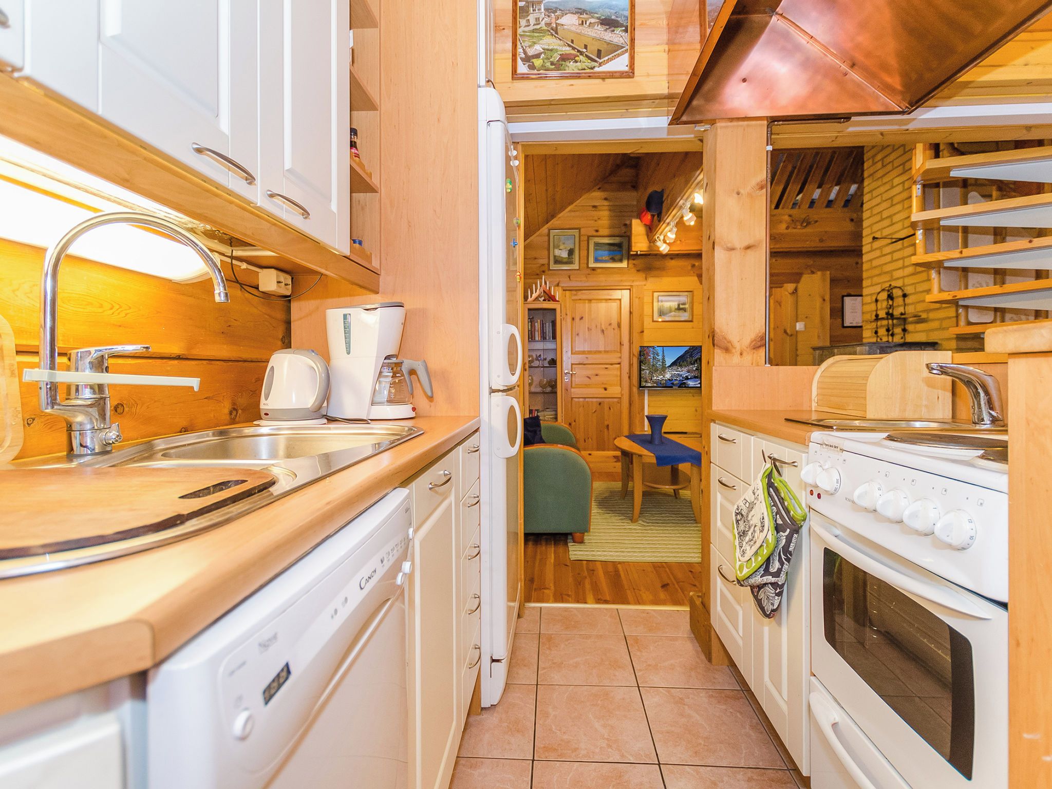 Eine kleine Küche mit Spüle, Kaffeemaschine und Herd.