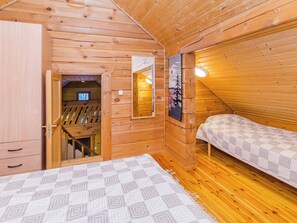 A wooden interior with a bunk bed, a small desk, and a window. - Villa käpytikka by Interhome (Liperi)