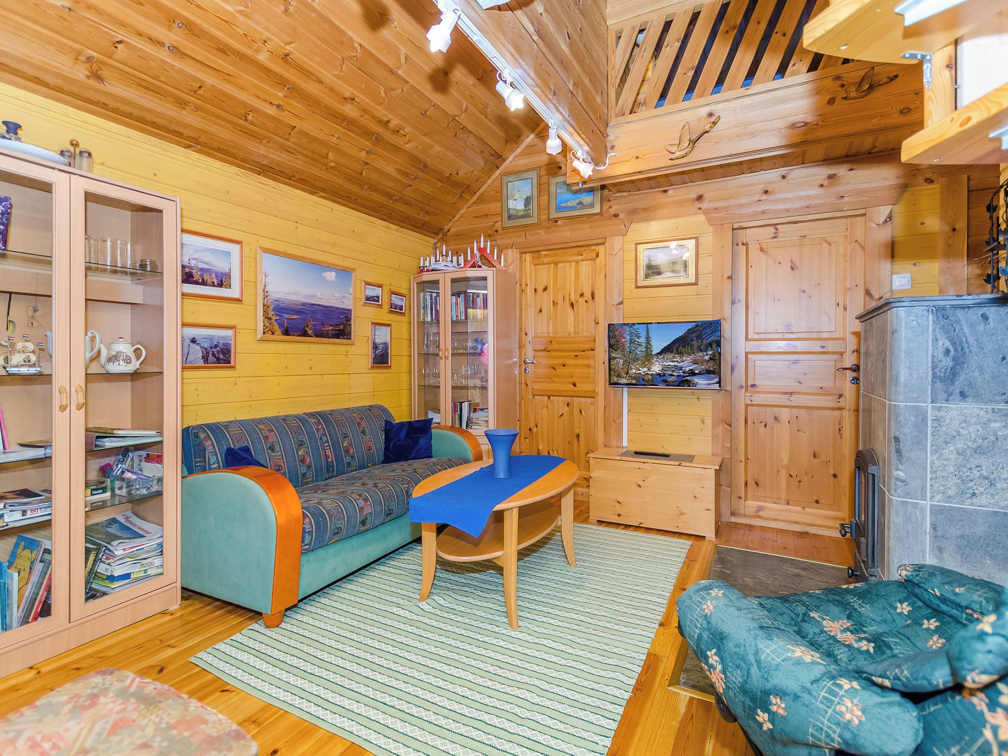 Un intérieur de chalet chaleureux avec un canapé, une table et un meuble avec des portes en verre.