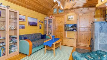 Un intérieur de chalet chaleureux avec un canapé, une table et un meuble avec des portes en verre.