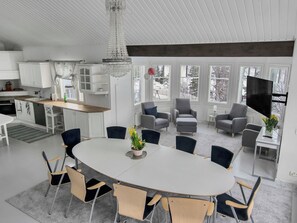 Un interior moderno con comedor, cocina y zona de estar.