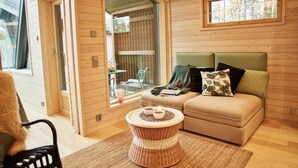 Un intérieur chaleureux avec un canapé, une table basse en osier et un fauteuil.
