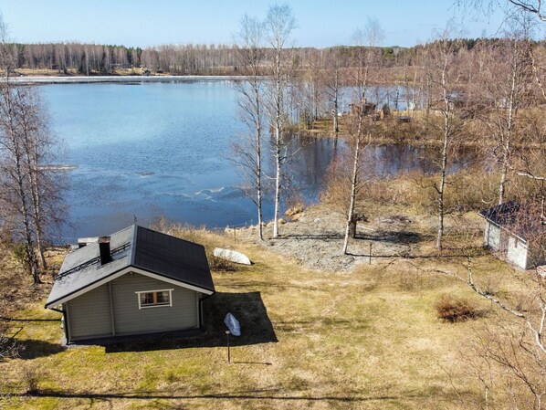 A house with a sloped roof, a small window, and a grassy yard.