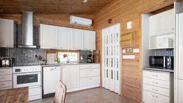 Een koelkast, een magnetron, een vaatwasser, kookgerei, borden en bestek