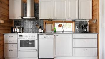 Een koelkast, een magnetron, een vaatwasser, kookgerei, borden en bestek