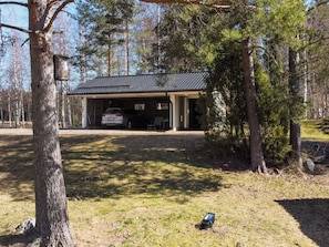 A two-story building with a garage, surrounded by trees.