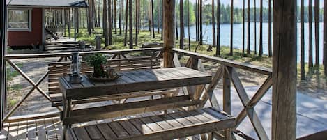 Eine Holzterrasse mit Picknicktischen und Bänken mit Blick auf einen See.