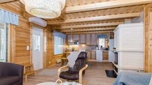 Un intérieur de chalet chaleureux comprenant un espace de vie, un coin repas et une cuisine.