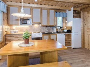 Una cocina moderna con armarios de madera, una isla central, microondas, estufa, fregadero y refrigerador.