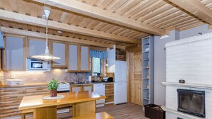 Une cuisine moderne avec des meubles en bois, un four à micro-ondes encastré et une cheminée blanche.