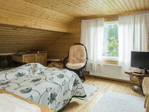A cozy room with a bed, a chair, a desk with a computer, and a window with curtains. - Vacation home Käpylä by Interhome (Kuhmo)