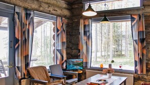 A cozy cabin interior with a sofa, a table, and a TV.
