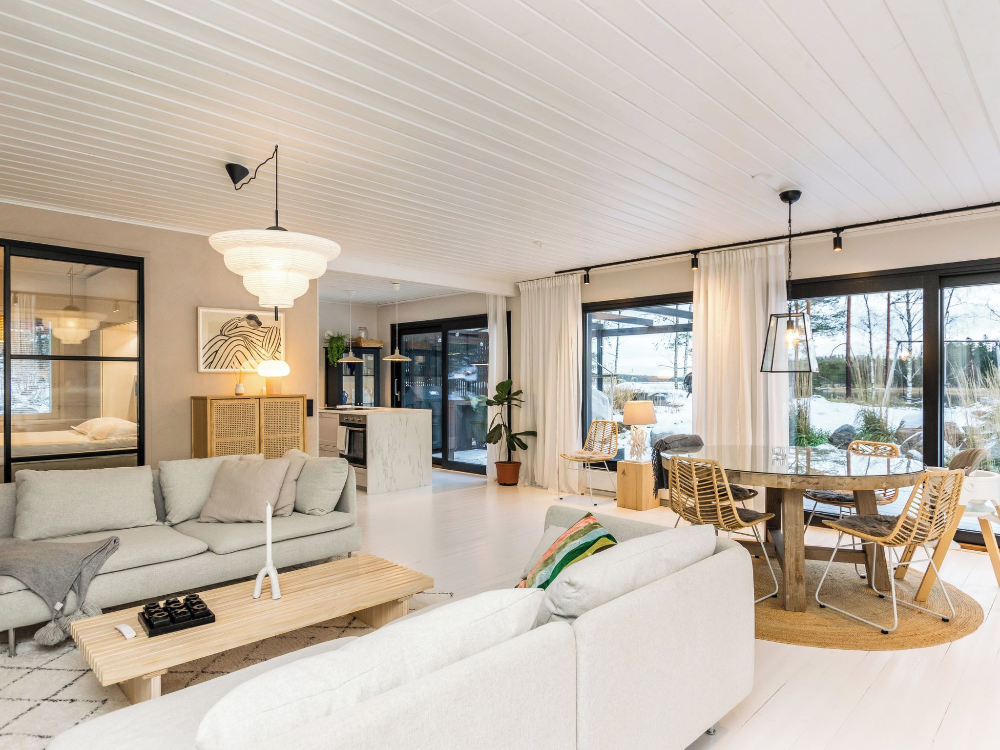 A modern living room with a sofa, coffee table, and dining area with chairs.