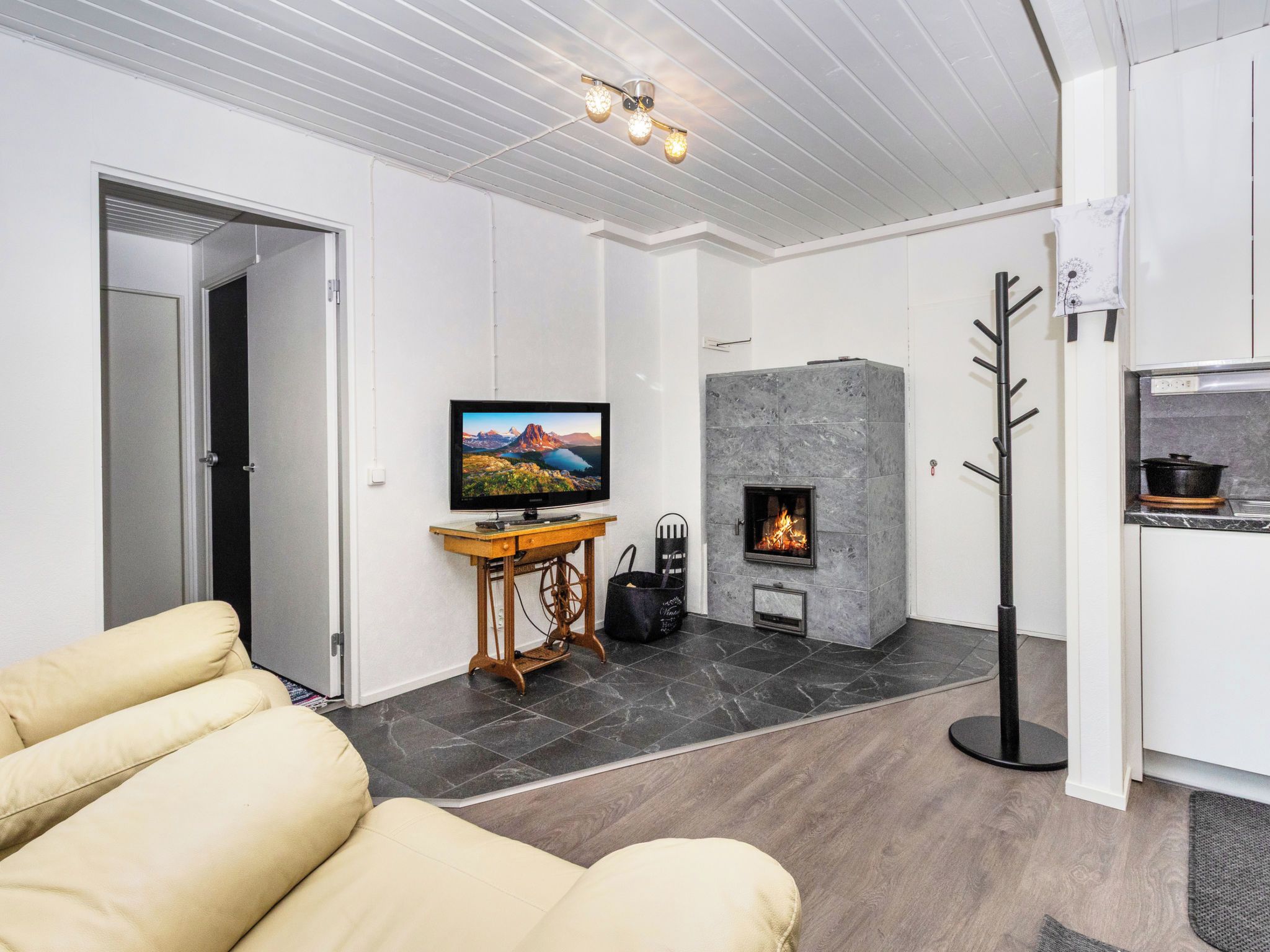A modern living room with a fireplace, a television, and a sofa.