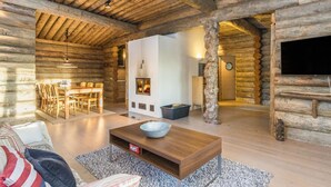 A log cabin interior with a dining area, a living room with a coffee table, and a TV mounted on the wall. - Kaasavuoren ranta by Interhome (Naantali)