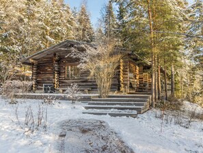 A log cabin with a porch and steps leading to the entrance, surrounded by snow-covered trees. - Kaasavuoren ranta by Interhome (Naantali)