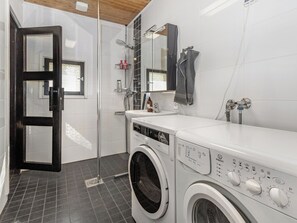 A modern bathroom with a washing machine, a shower, and a mirror. - Mokko-mökki by Interhome (Sodankylä)