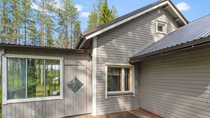 A two-story house with a deck and a small attached shed.