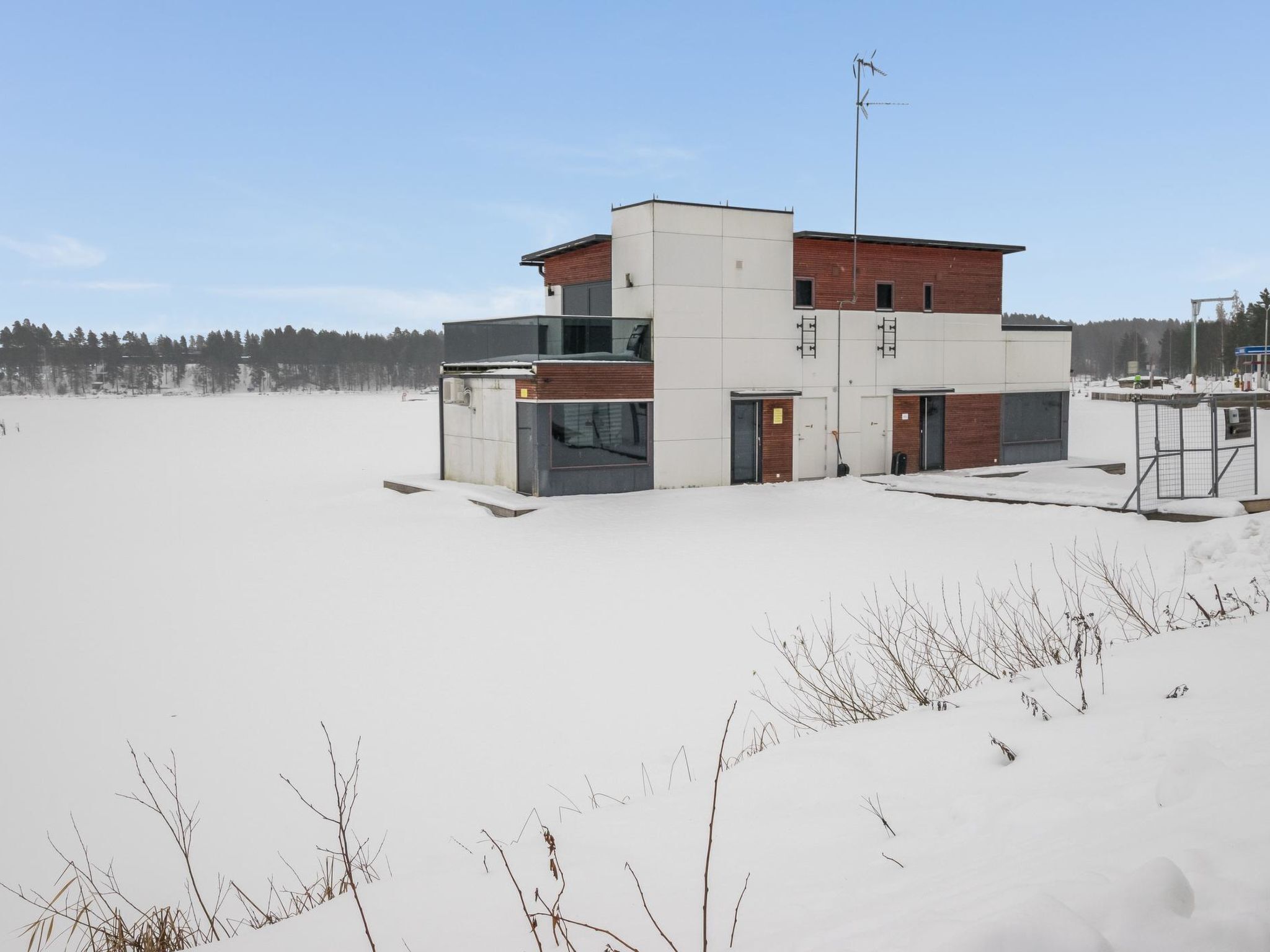 Moderni rakennus, jossa on tasakatto, suuret ikkunat ja näkyvissä oleva antenni.