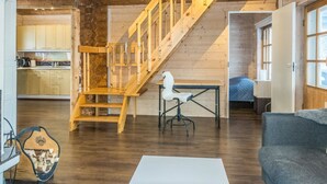 A wooden interior with a staircase, a dining table, and a sofa. - Puljunharju by Interhome (Sodankylä)