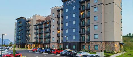 A multi-story Staybridge Suites hotel with a parking lot in front.