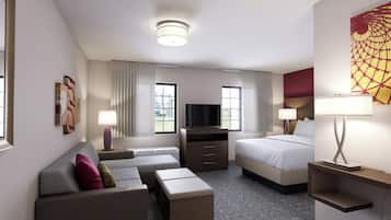 A hotel room with a sofa, a bed, a TV, and a desk.